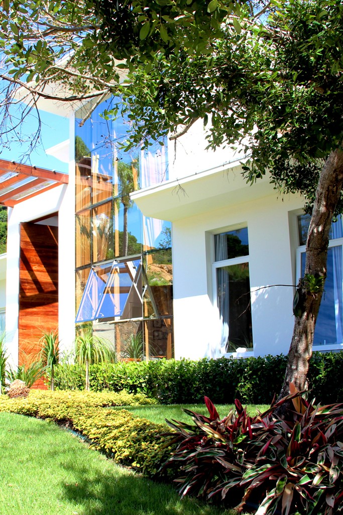 Projeto paisagístico de jardim residencial com marantas sanguíneas sob árvore aroeira