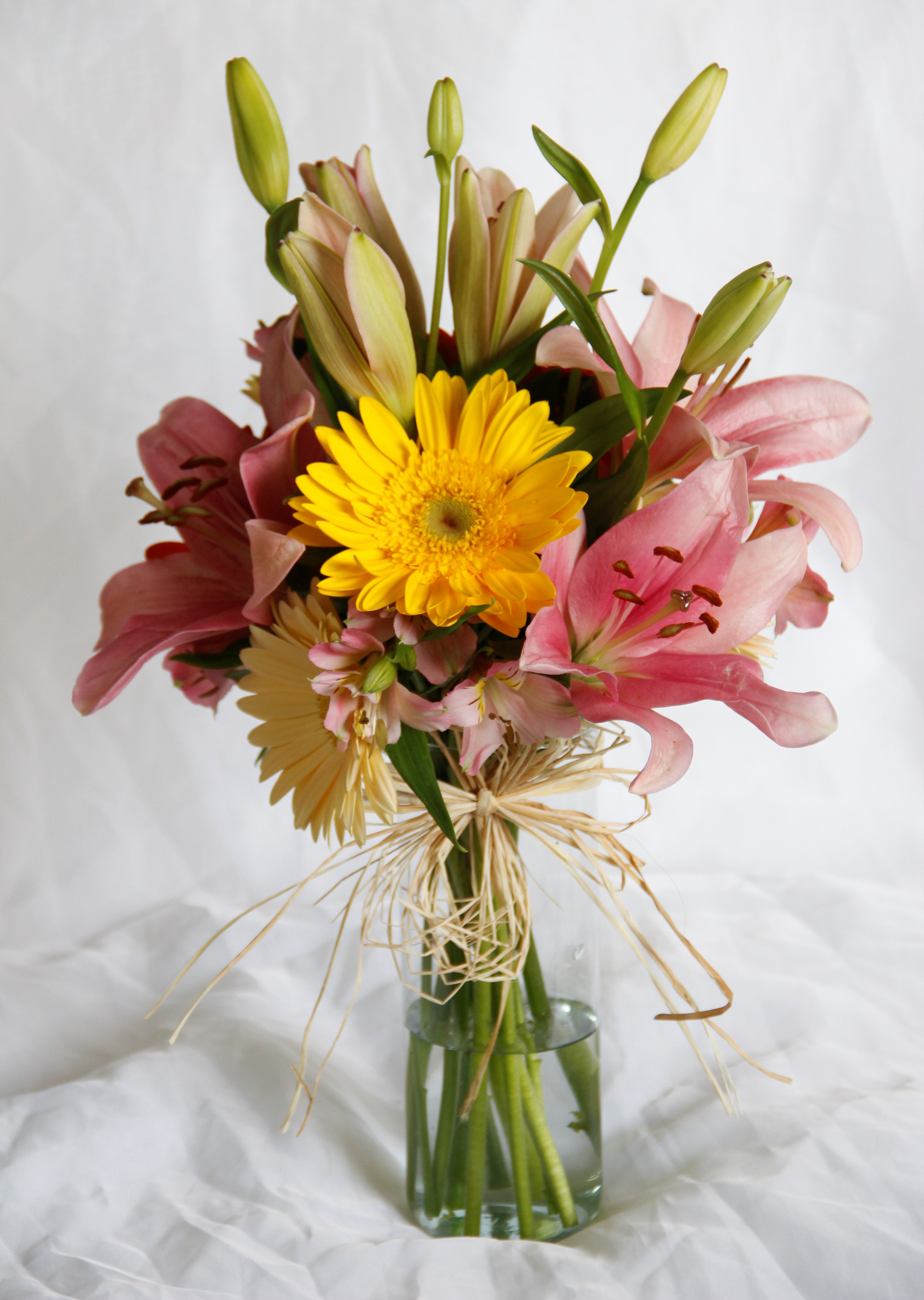 Arranjo floral de gérberas e lírios no vidro