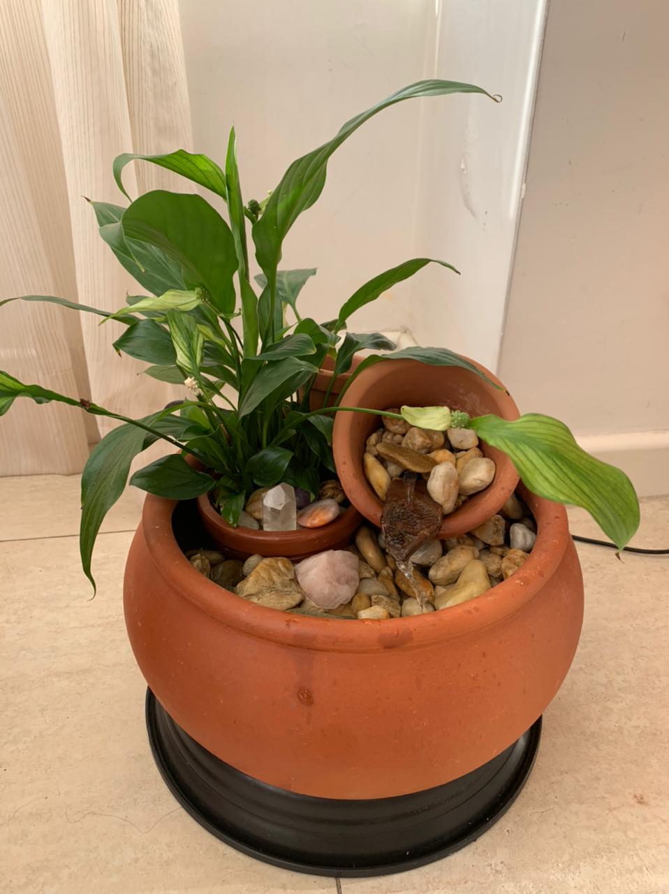 Fonte de água em ceâmica com lírio-da-paz